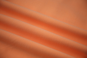 Coral solid stretch fabric draped in soft folds